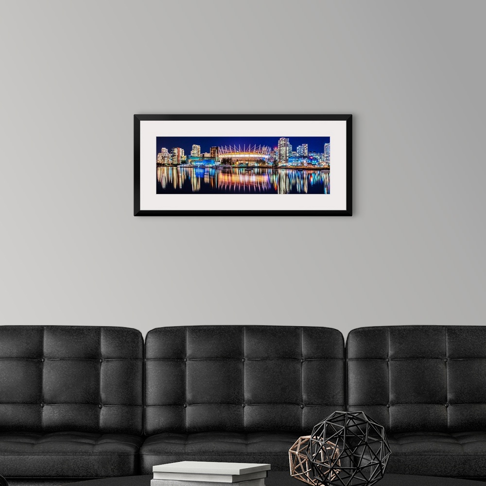 A modern room featuring Panoramic photograph of BC Place Stadium and part of the Vancouver skyline lit up at night and re...