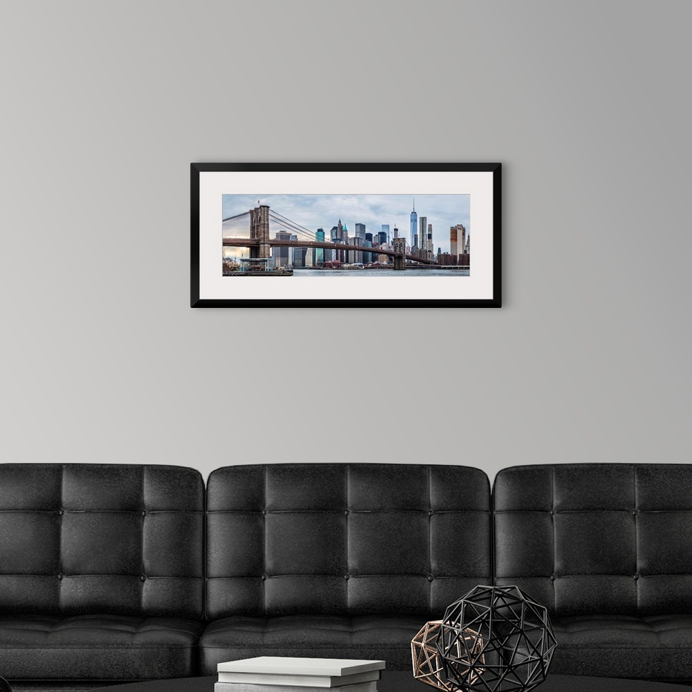 A modern room featuring View of the New York City skyline under an overcast sky, with the Brooklyn Bridge, from across th...