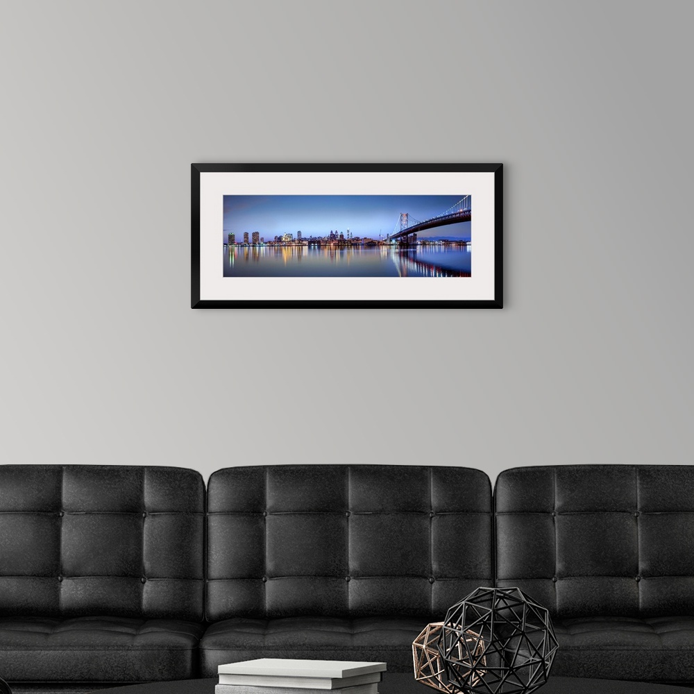 A modern room featuring Panoramic photo of the Philadelphia city skyline reflected in the water at night, with the Benjam...
