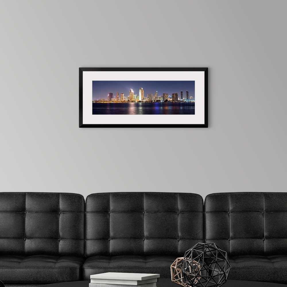 A modern room featuring Panoramic photograph of the San Diego, California skyline lit up at night from across the water.