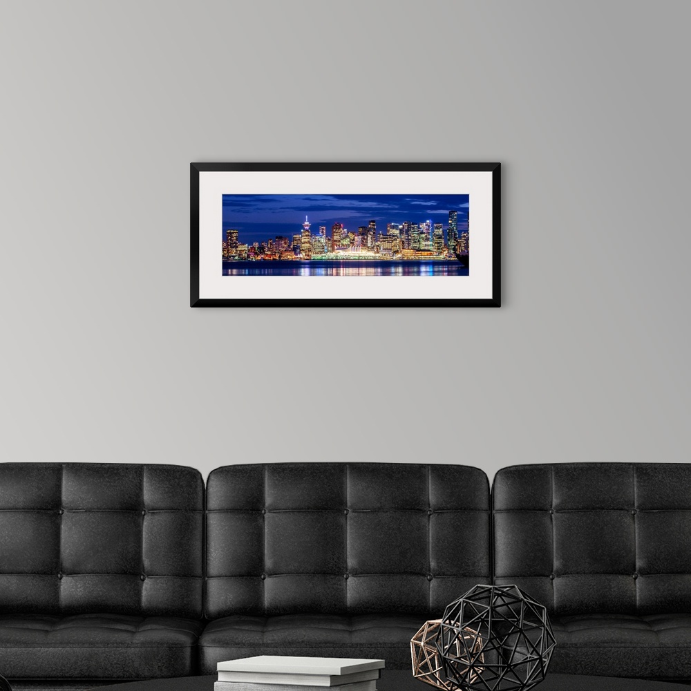 A modern room featuring Panoramic photograph of the Vancouver, British Columbia skyline lit up on a dark purple night and...