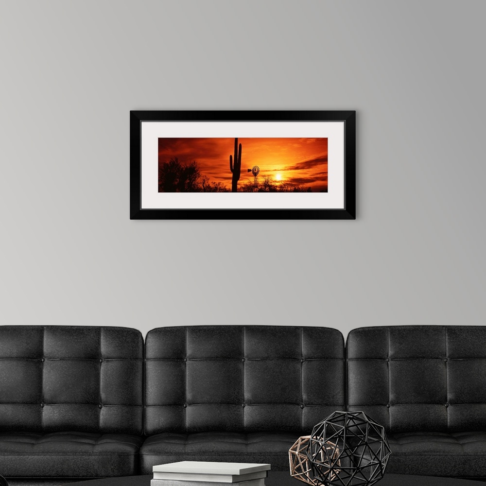 A modern room featuring Panoramic photograph displays the sun heading towards the horizon and spreading its remaining lig...