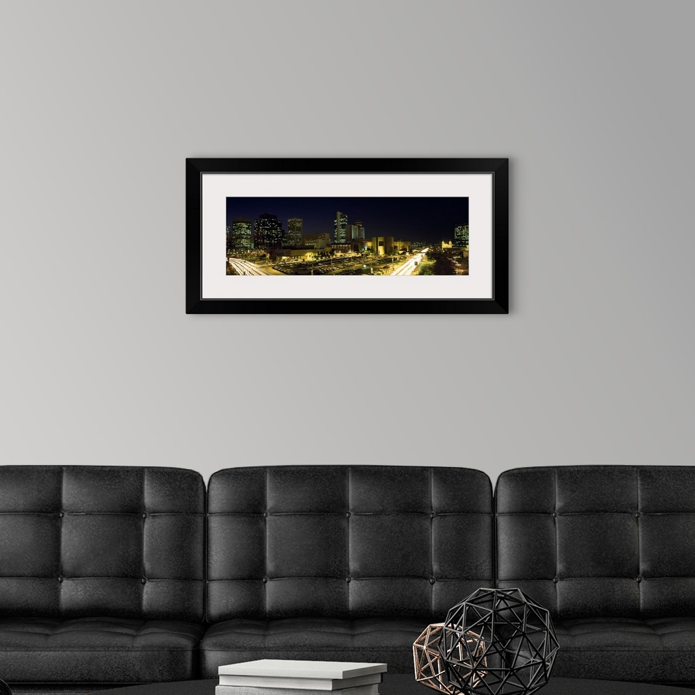 A modern room featuring Panoramic canvas of buildings in Phoenix illuminated at night.