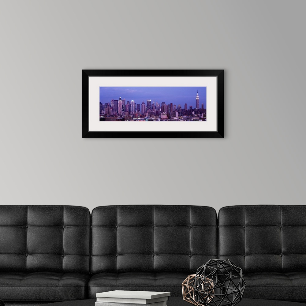A modern room featuring This panoramic photograph was taken at dusk of the Manhattan skyline from across the water.