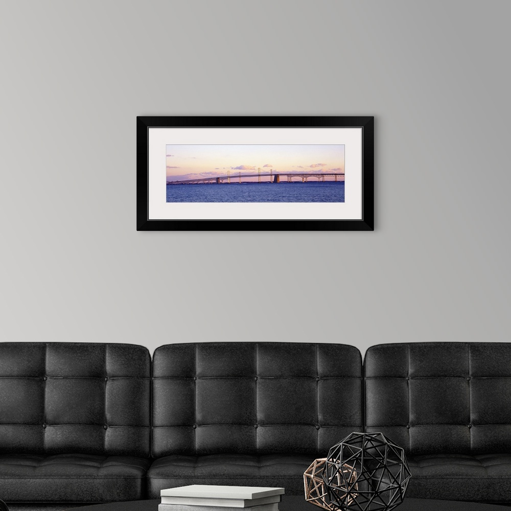 A modern room featuring This large panoramic shot is taken of the Chesapeake Bay Bridge during a sunset.
