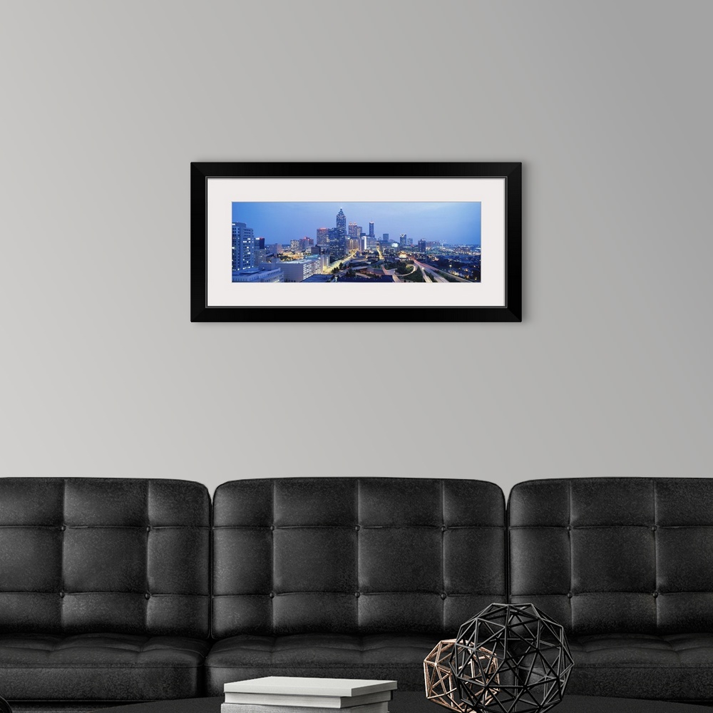 A modern room featuring An aerial photograph taken of downtown Atlanta with the buildings illuminated and the streets lit...
