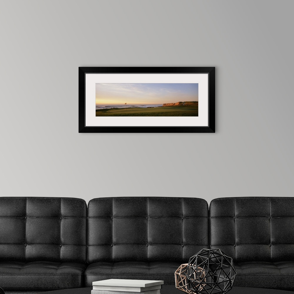 A modern room featuring Panoramic photograph on a large canvas of the green on a golf course, along the coast of Half Moo...