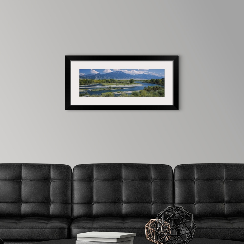 A modern room featuring Big wall panoramic wall docor of a river leading into a bigger body of water and mountains encase...