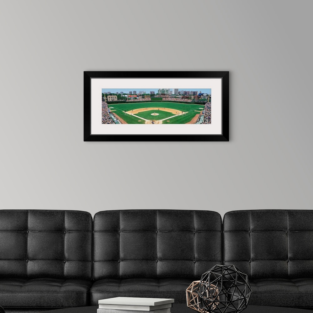 A modern room featuring Panoramic photograph of Wrigley Field with Chicago skyline in the distance.  Stadium is full of p...