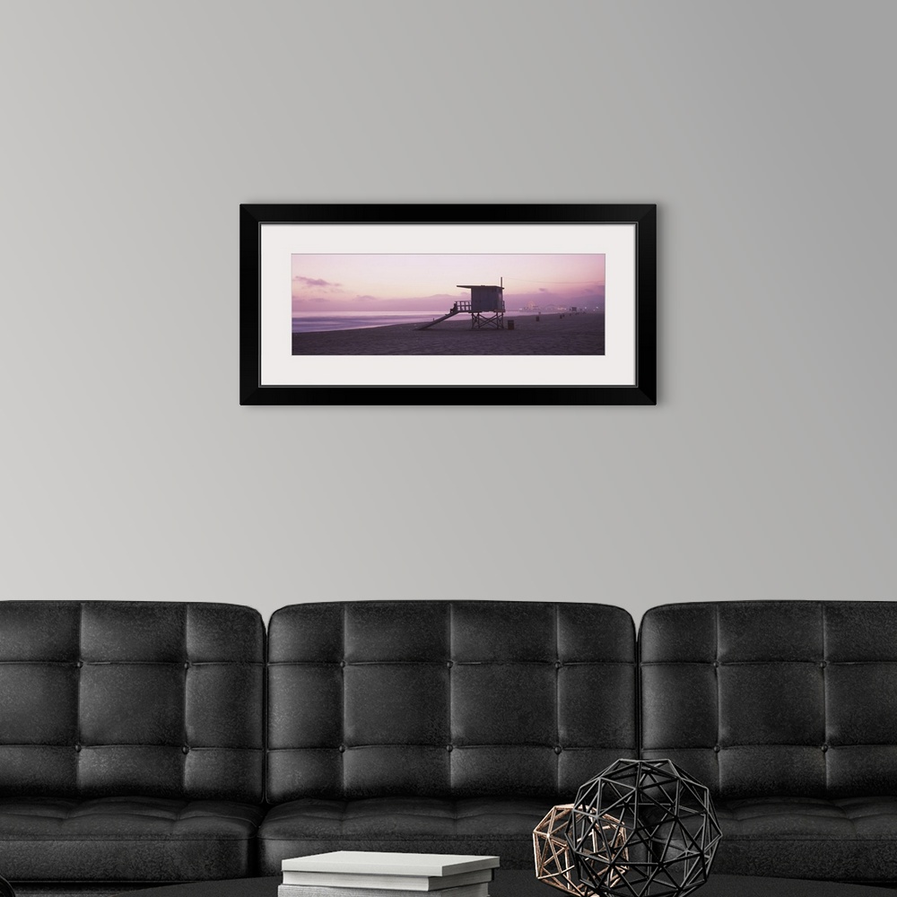 A modern room featuring Long horizontal photo print of a lifeguard station on the beach along the Pacific ocean with the ...