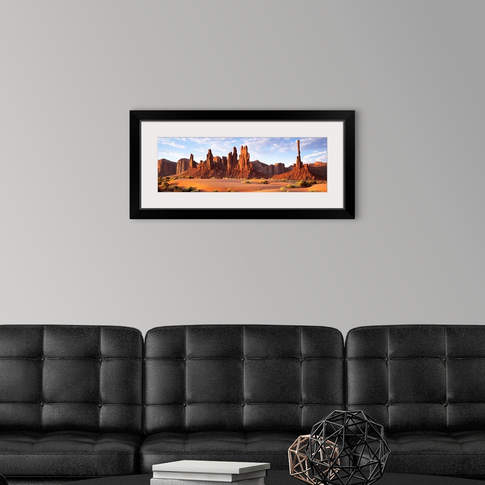 A modern room featuring Panoramic photograph composed of a desert landscape filled with sand and small patches of vegetat...