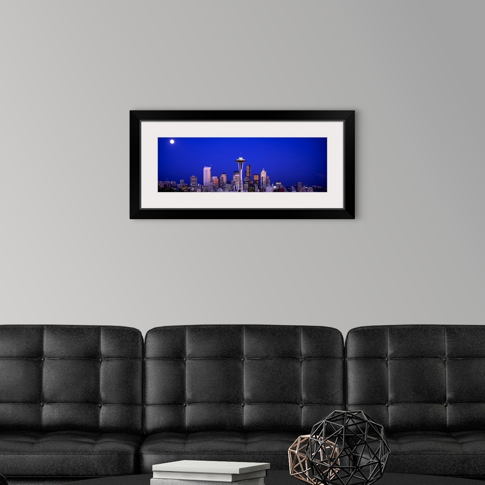 A modern room featuring The city skyline illuminated in the moonlight.