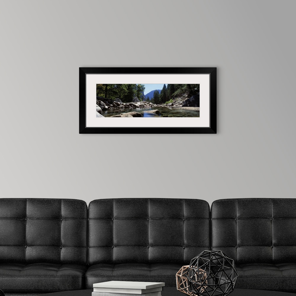 A modern room featuring Panoramic photograph taken from the surface of a quietly moving stream littered with rocks of all...