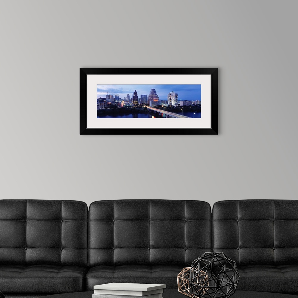 A modern room featuring Panoramic photograph taken within the capital city of Texas shows the skyline at nighttime sittin...