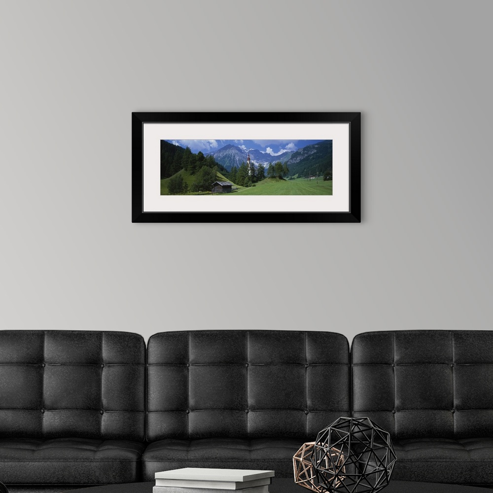 A modern room featuring Large canvas print of rugged mountains in the background of a countryside field with a barn, fenc...