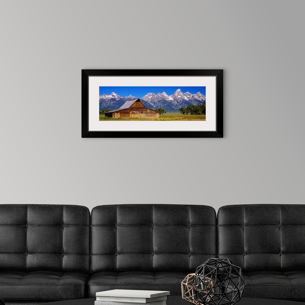 A modern room featuring A panoramic landscape photograph of farmland, the T.A. Moulton barn, and the massive mountain pea...