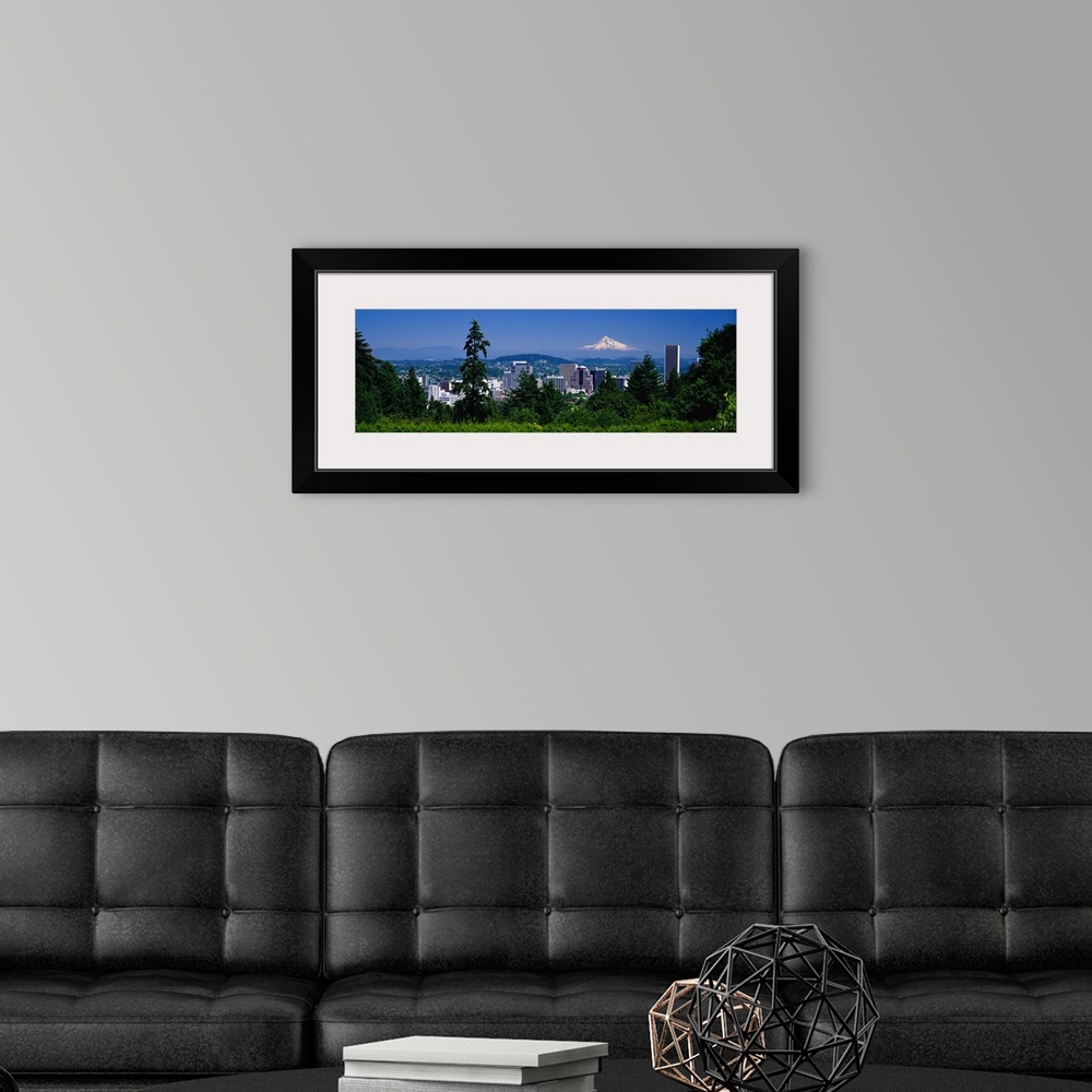 A modern room featuring Landscape, panoramic photograph looking down at the Portland skyline from a tree lined hillside.