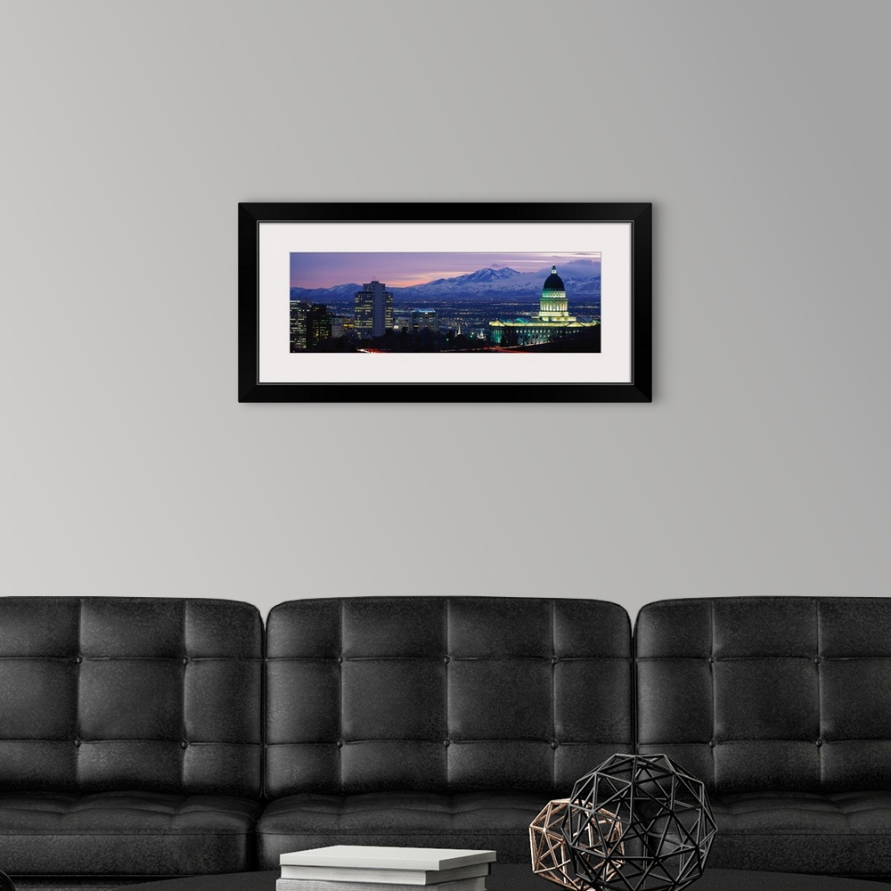 A modern room featuring Panoramic Rocky Mountains and downtown Salt Lake City, Utah as the last of the sun dips below the...