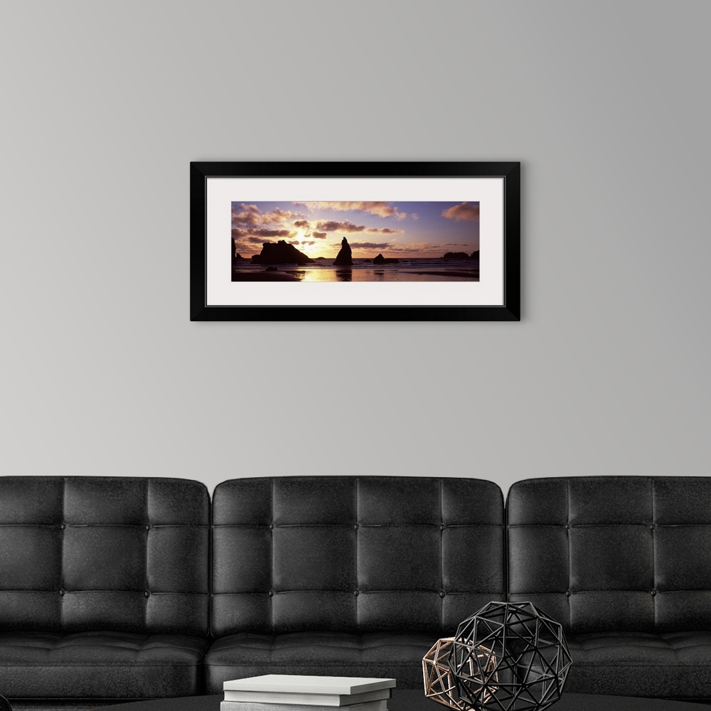 A modern room featuring Photo of the sun setting behind rock formations sticking up in the shallow waters of the ocean cr...