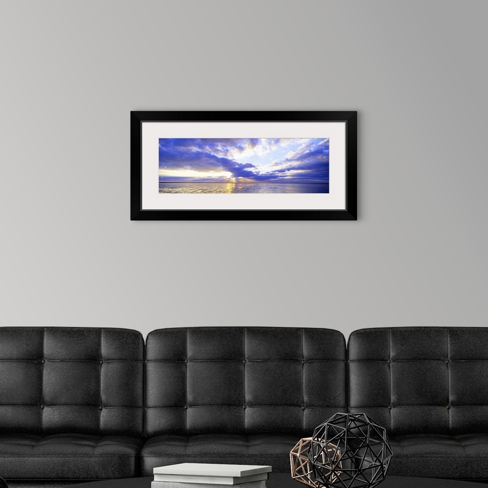 A modern room featuring Panoramic photo print of a sunset over an ocean.