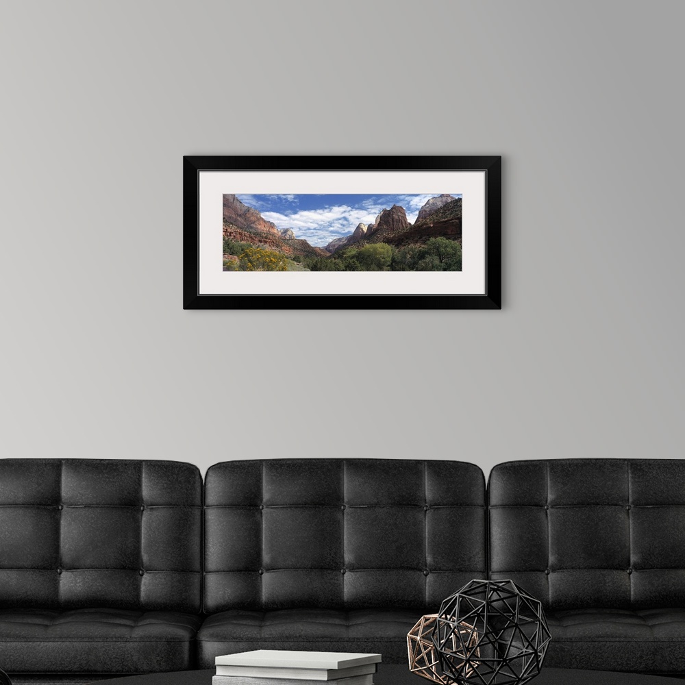 A modern room featuring Panoramic photograph of canyon under a cloudy sky with dense shrubbery in the foreground.