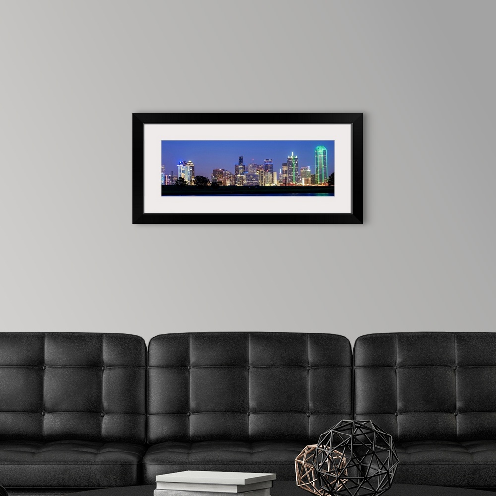 A modern room featuring The city skyline of Dallas at night.
