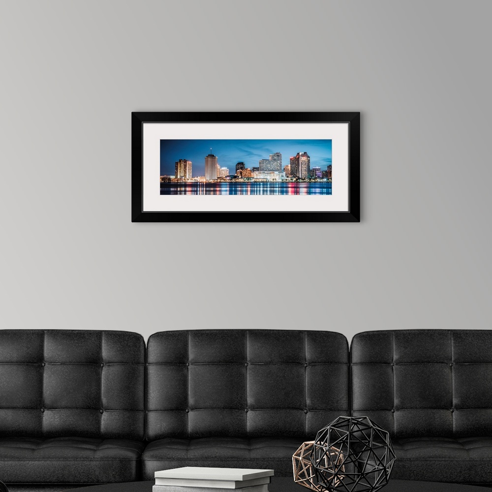 A modern room featuring Panoramic photograph of the New Orleans skyline lit up at dusk and reflecting colorful bands onto...