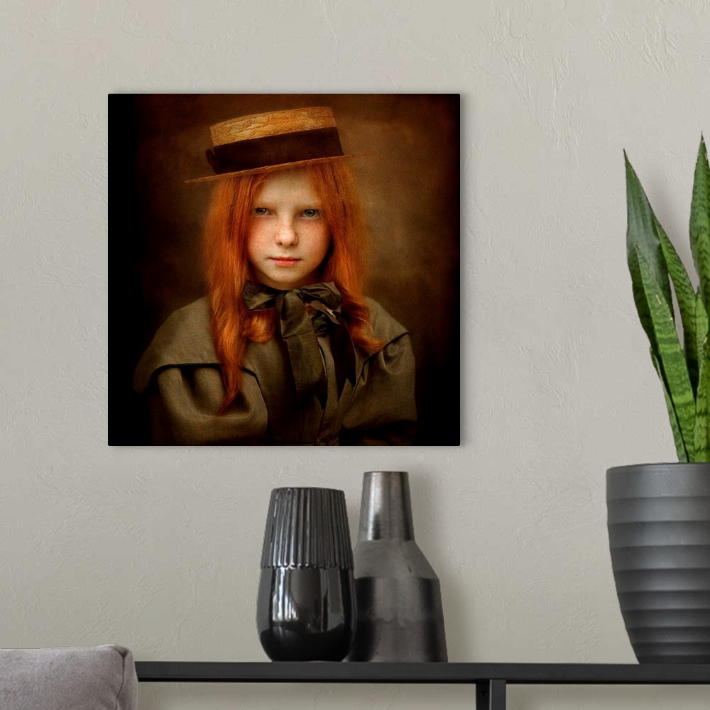 A modern room featuring A child with long red hair wearing a straw hat and a ribbon tied in a bow.