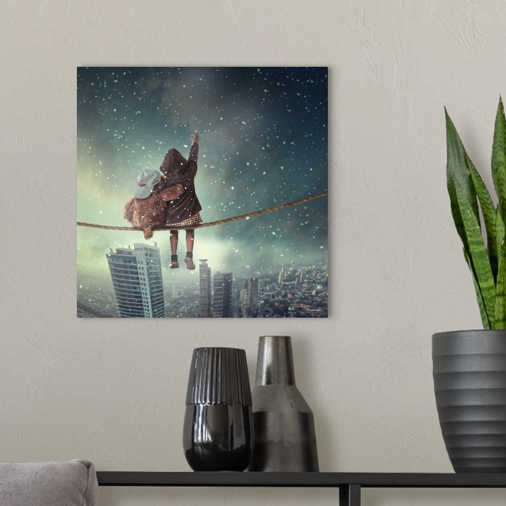 A modern room featuring Surreal image of a child and a teddy bear sitting on a cable overlooking a city as snow falls.