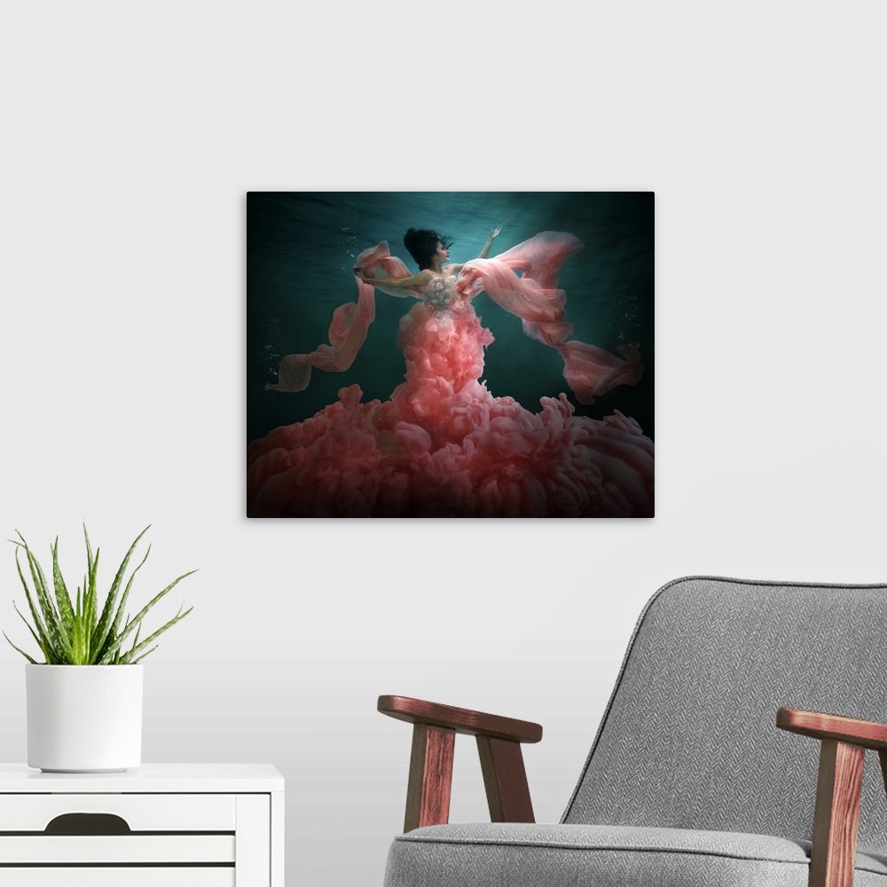 A modern room featuring Underwater photo of a woman wearing a billowing pink dress.