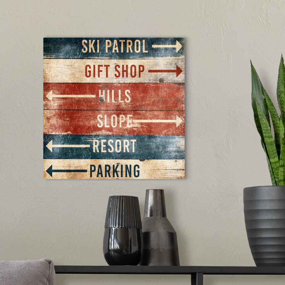 A modern room featuring A wooden sign with arrows pointing the way to area at a ski resort.