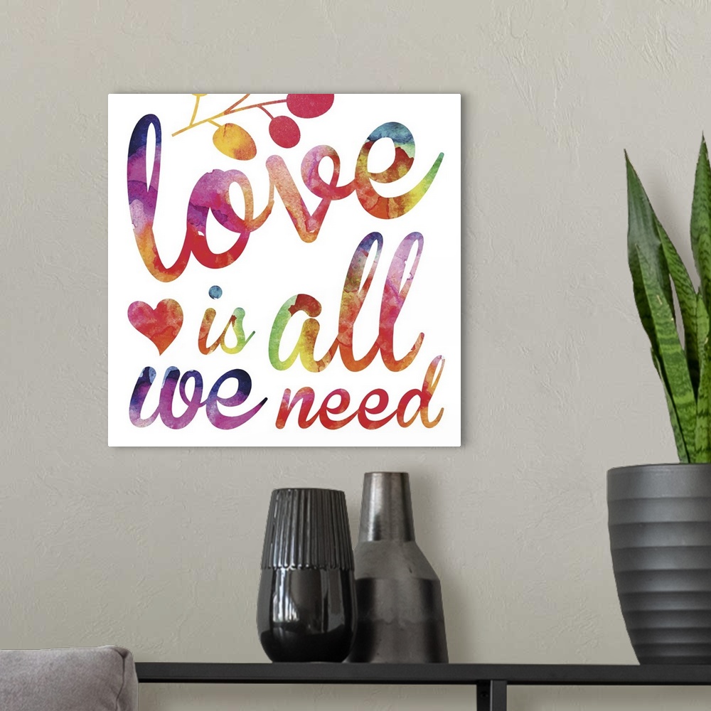 A modern room featuring "Love is all we need" in script lettering in  rainbow watercolors.