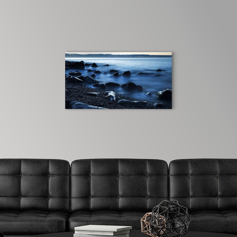 A modern room featuring Beautiful blue misty ocean washing in against rocks on a West Coast beach; Greymouth, New Zealand