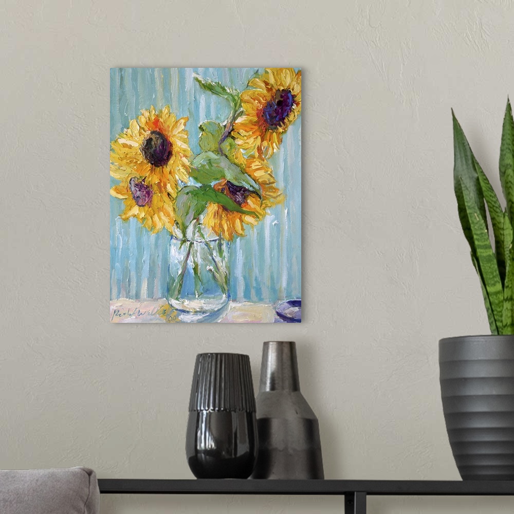 A modern room featuring Sunflowers in a clear glass vase.