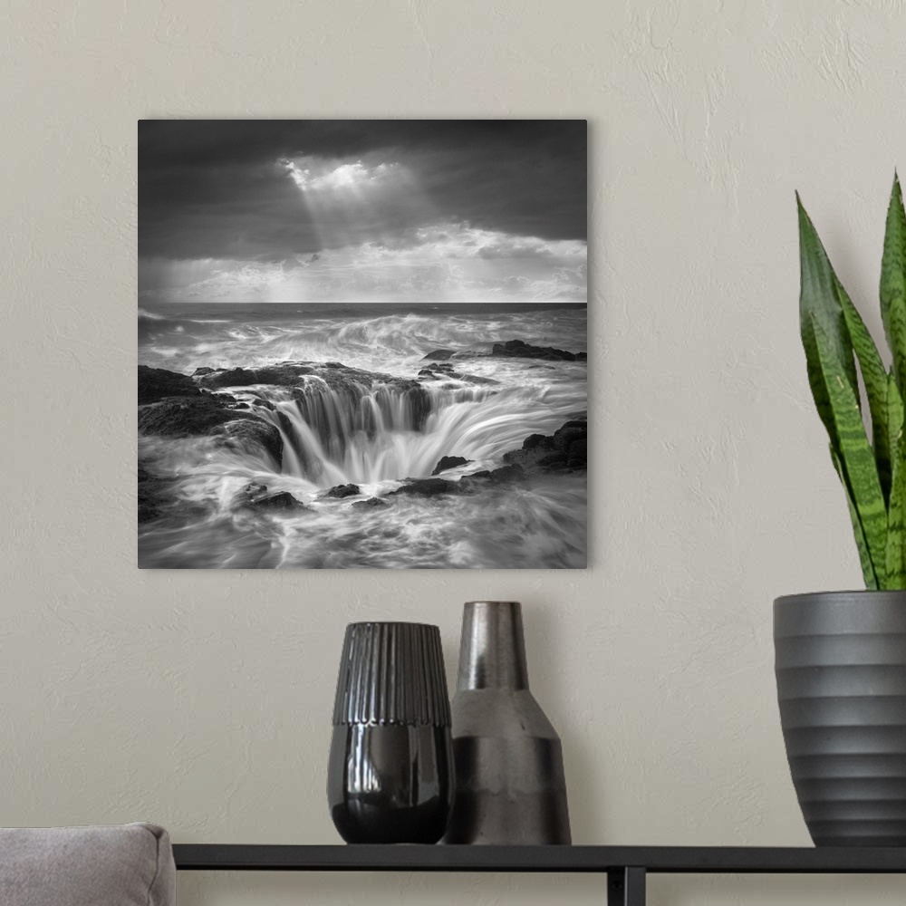A modern room featuring An artistic black and white photograph of a tidal pool with rushing water flowing in and around t...