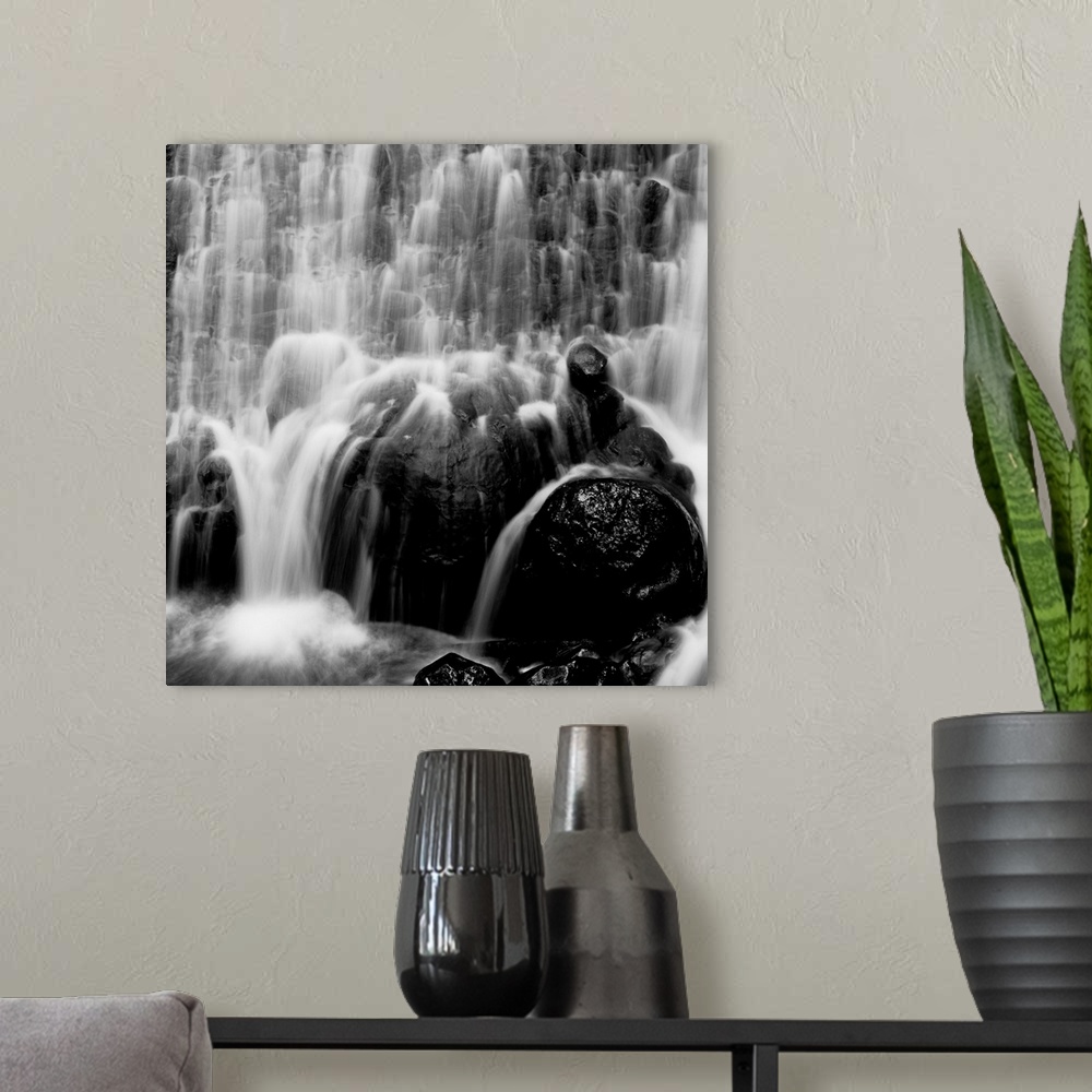 A modern room featuring waterfall, rocks, photographic, black and white
