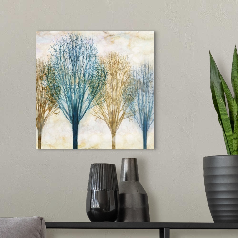 A modern room featuring Square artwork with Winter trees in blue and brown hues with a foggy sepia toned background.