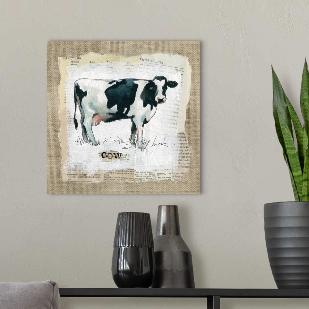 A modern room featuring Square burlap collage art of a cow painted on top of newspaper clippings with the word "cow" stam...