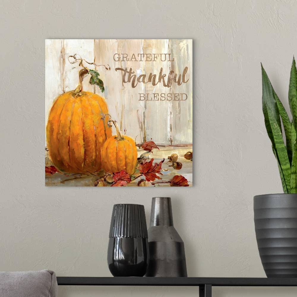 A modern room featuring "Grateful, Thankful, Blessed" written on a square canvas with illustrated pumpkins, acorns, and F...