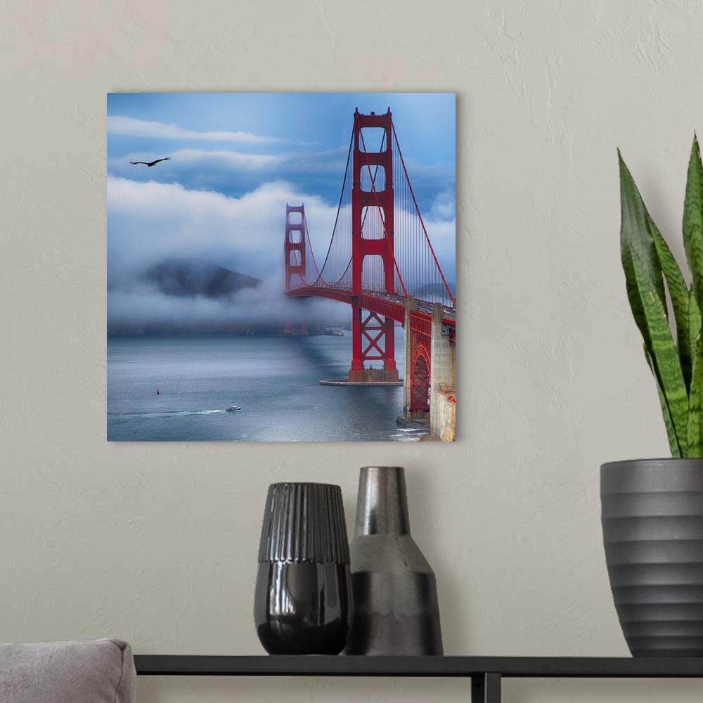 A modern room featuring Square photograph of the Golden Gate Bridge in San Francisco with a boat in the bay and a bird in...