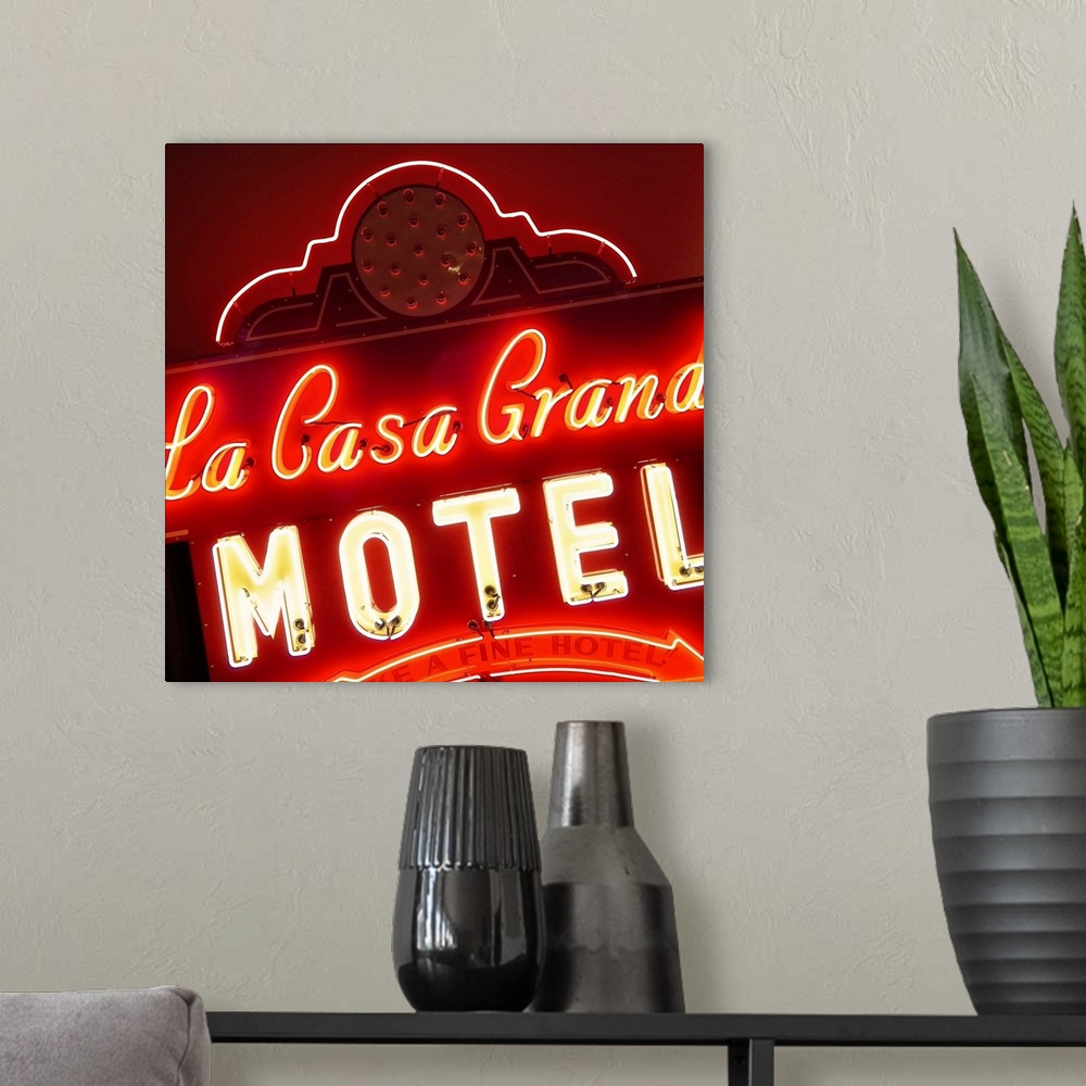 A modern room featuring Square photograph of a lit, neon red sign that says "La Casa Grande Motel"