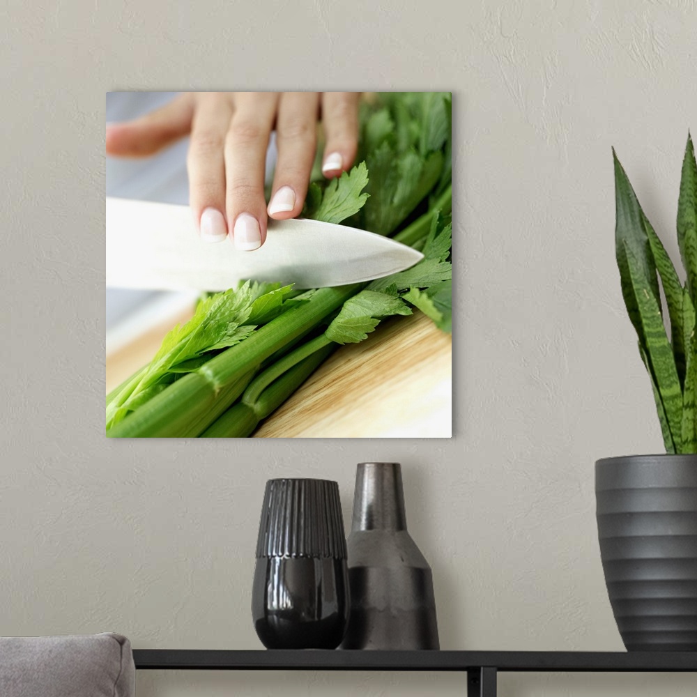 A modern room featuring Close-up of a woman's hand chopping celery