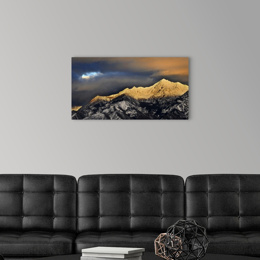 A modern room featuring Clouds hover over granite peaks of Wasatch Mountains.