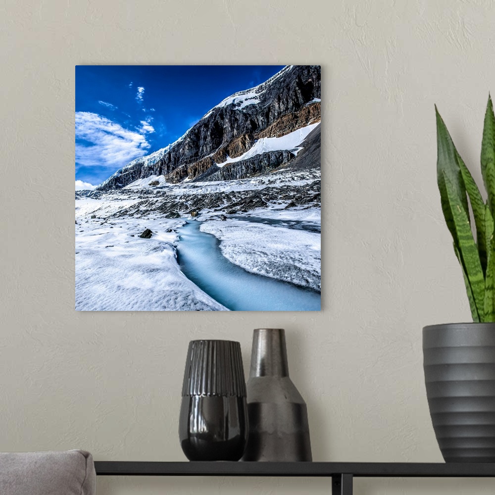 A modern room featuring Snow and ice on the mountains, and a  stream of runoff freezes over on the Athabasca Glacier off ...
