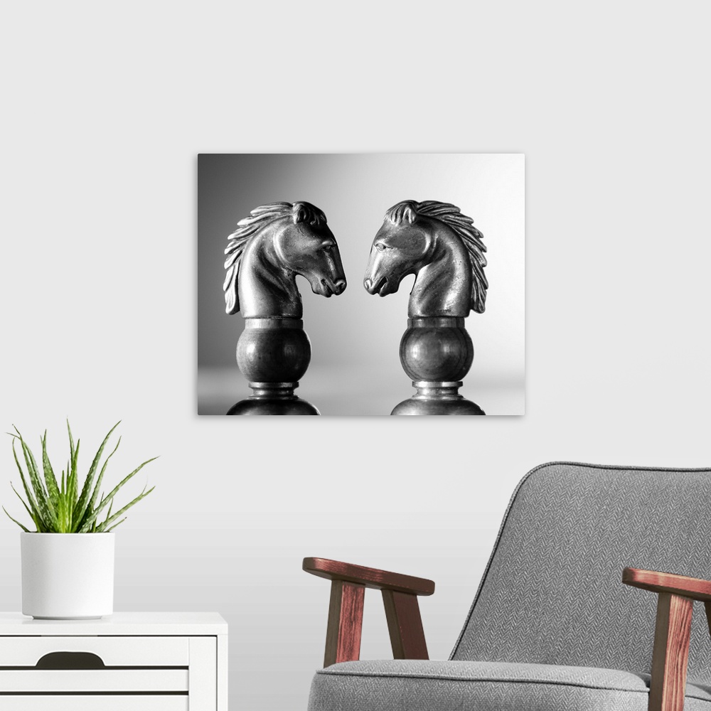 A modern room featuring Two chess knights facing off.  Profile shots of two horses in a chess game.
