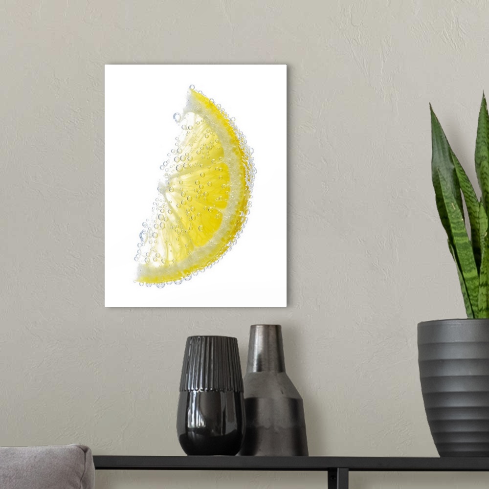 A modern room featuring A juicy ripe organic lemon wedge fruit submerged in clean clear refreshing water and covered in b...