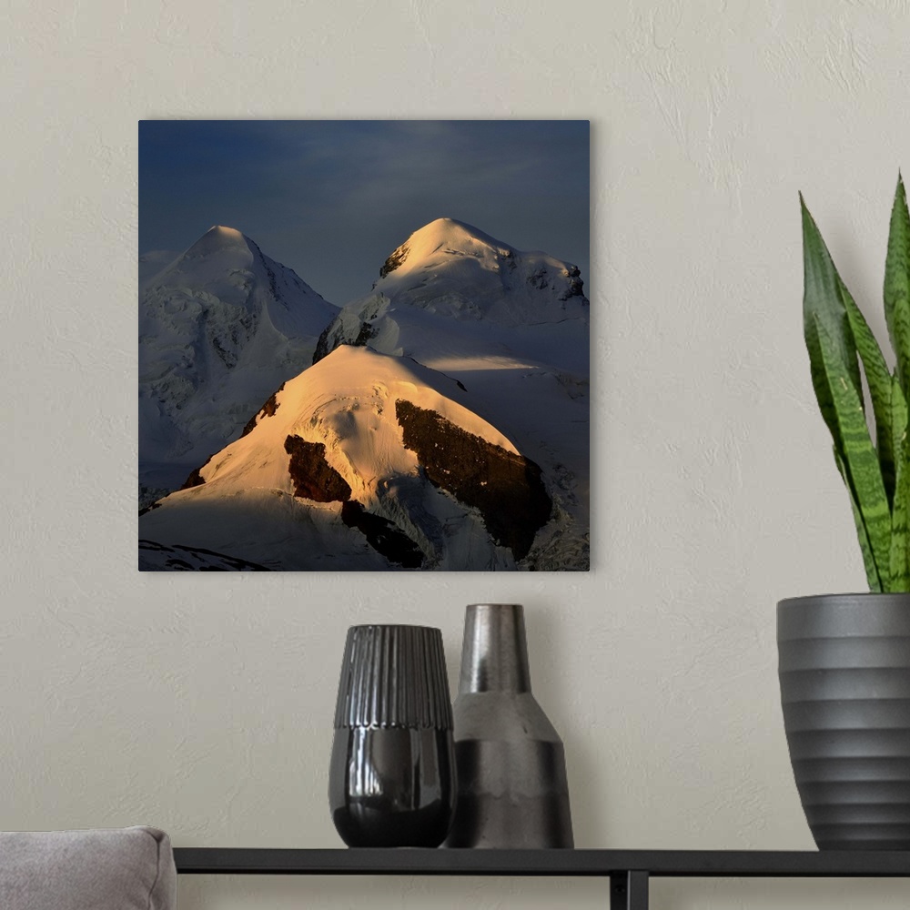 A modern room featuring Mountain landscape,sunriseon two swiss peaks Castor(4228) and Pollux (4092), blue sky, golden sun...