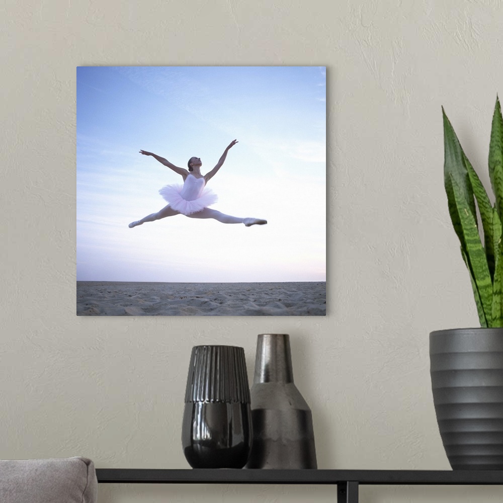 A modern room featuring Teenage ballerina (16-18) performing leap on beach, low angle view