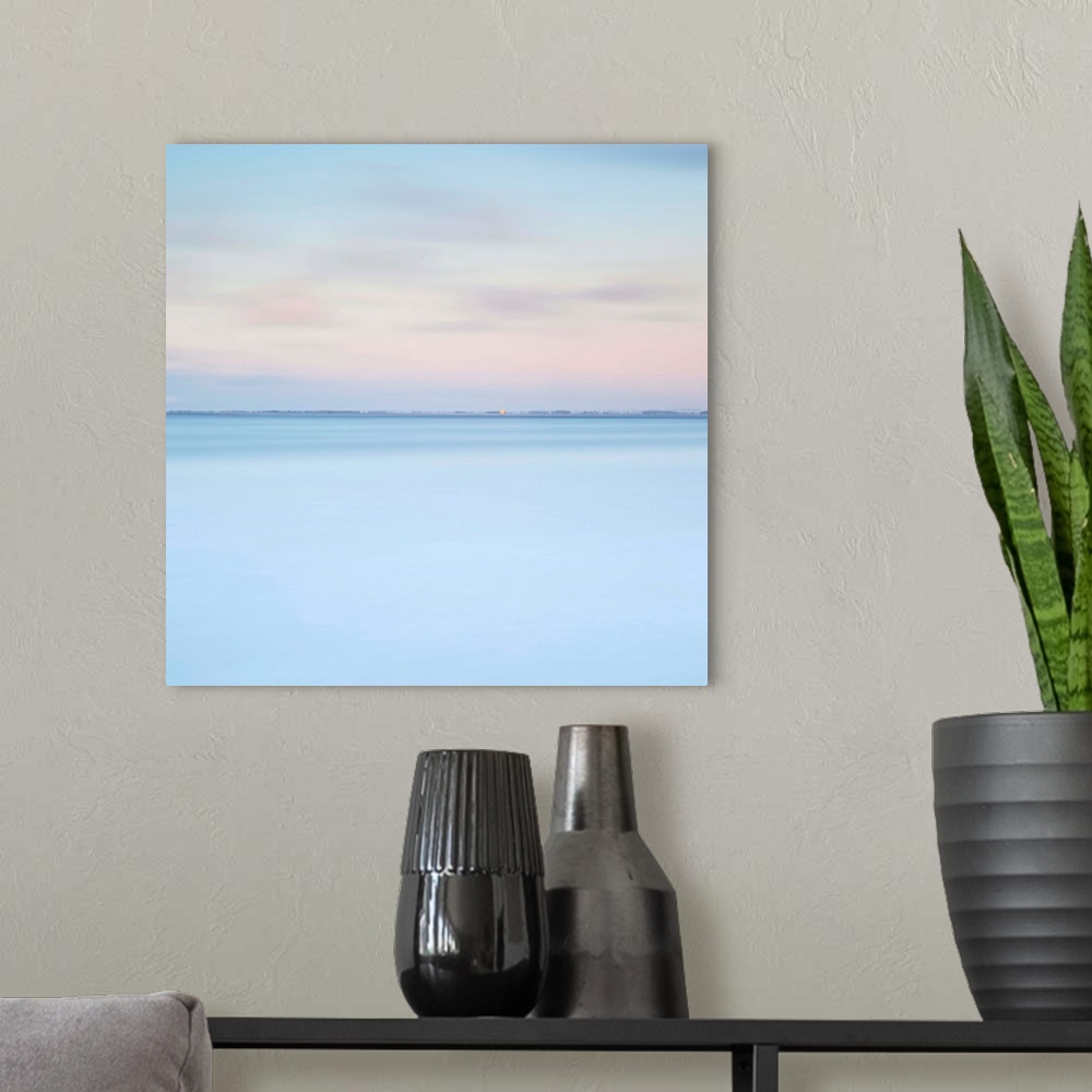 A modern room featuring A zen minimalist blue and pink dawn over water with just a distant horizon line and layers of pur...