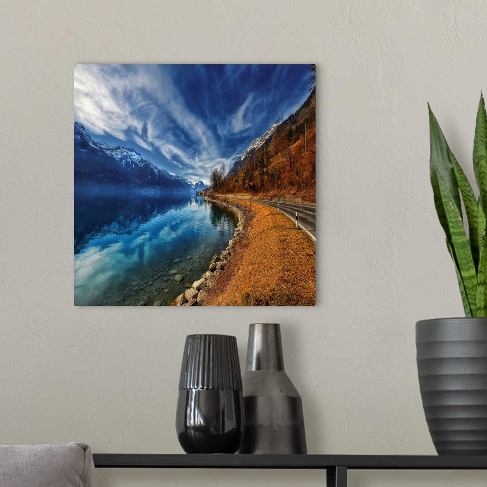 A modern room featuring This oversize piece is a picture taken of a winding road with a breathtaking view of mountains on...